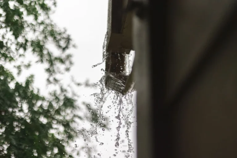 Monsoon rain pouring off a roof gutter at a Peoria, AZ home
